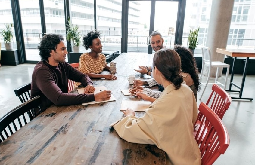 Group of professionals sitting around a table conducting a leadership interview in a modern office setting